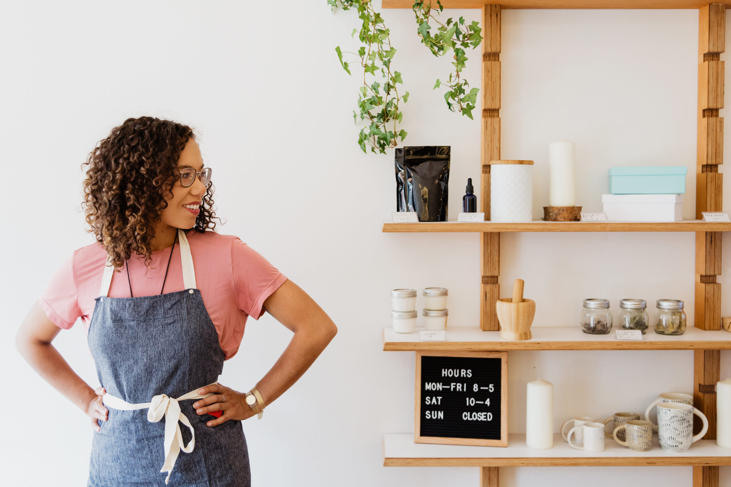 Mulher de avental sorri diante dos produtos exposição na estante de sua loja. Imagem ilustrativa para texto sobre a ferramentas Canvas de Empreendedorismo Feminino da Semente Negócios.

Foto da Sarah Pflug do Burst.
